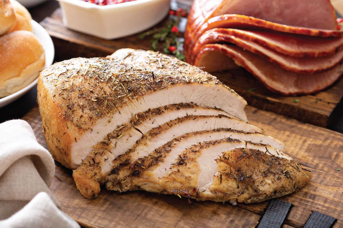 Sliced roasted turkey breast on a wooden cutting board