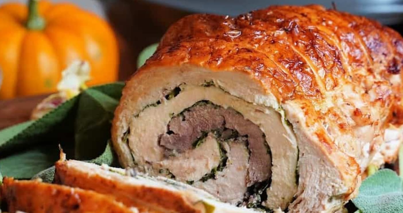Sliced turducken roll showing layers of turkey, duck, chicken, and stuffing